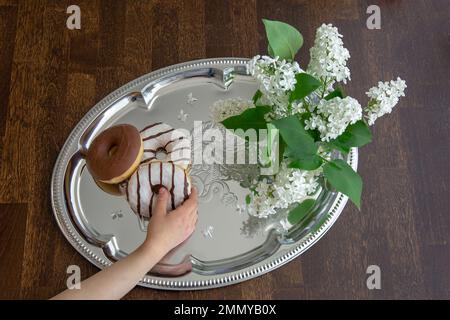 Ciambelle e mano umana, vista dall'alto Foto Stock