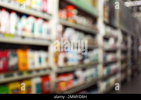 Vista sfocata dei supporti di stoccaggio con materiali da costruzione diversi nel magazzino all'ingrosso Foto Stock
