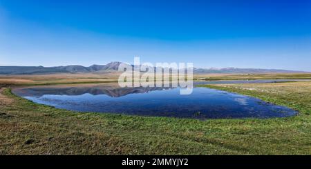 Montagne che si riflettono in un lago lungo la catena montuosa di AT-Bashy, la regione di Naryn, il Kirghizistan Foto Stock