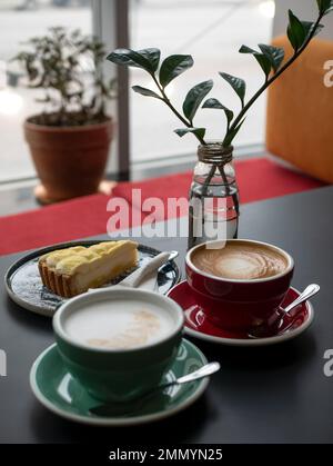 Cappuccino e latte con schiuma sulla parte superiore in tazze in ceramica per coppia o amici, messa a fuoco selettiva. Caffè mattina nel caffè Foto Stock