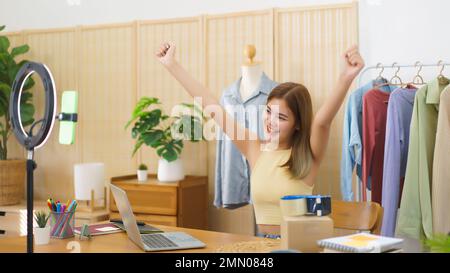 Concetto mercantile in linea, riuscito stilista delizioso con i vestiti effluenti in tensione di vendite. Foto Stock