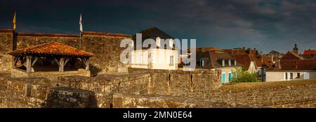 Francia, Pirenei Atlantici, Bearn, Navarrenx, vista panoramica della città sotto un cielo tempestoso al tramonto Foto Stock