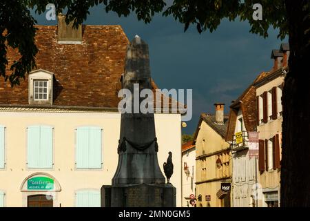 Francia, Pirenei Atlantici, Bearn, Navarrenx, vista di una statua di gallo su una piazza nel centro della città sotto un cielo tempestoso Foto Stock