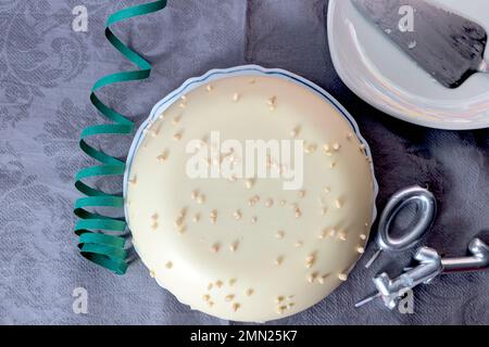 Torta al cioccolato bianco per il compleanno con numero di candele e sfondo con palloncini per la festa Foto Stock