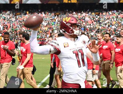 Carson Wentz, quartback dei comandanti di Washington, si scalda prima della partita contro le Eagles di Philadelphia al FedEx Field di North Englewood, M., 25 settembre 2022. Come continuazione della celebrazione del 75th° anniversario dell’aviazione militare statunitense, il generale Joel Jackson, comandante dell’AFDW, è stato onorato di essere sul campo per il lancio della moneta e di accettare la consegna della palla di gioco con il capo maestro Sgt. Leon Calloway, capo comando dell’AFDW. Foto Stock