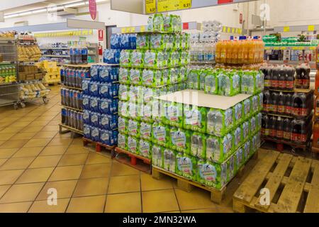 Fossano, Italia - 28 gennaio 2023: bottiglie in pet acqua e bibite su pallet in negozio INS italiano, INS è una catena di supermercati italiani di PAM Foto Stock