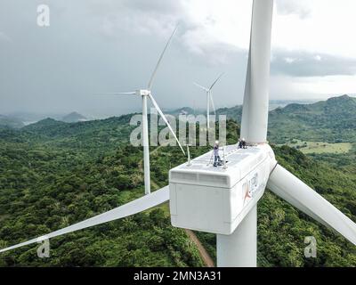 Due tecnici di turbine eoliche lavorano sulla navicella di una turbina nell'area di Sidrap Wind Farm a South Sulawesi, Indonesia. Foto Stock