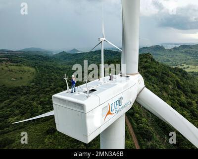 Due tecnici di turbine eoliche lavorano sulla navicella di una turbina nell'area di Sidrap Wind Farm a South Sulawesi, Indonesia. Foto Stock