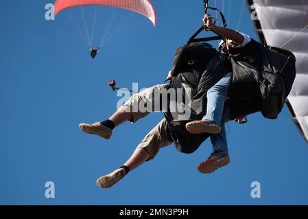 Due parapendio tandem volano contro il cielo blu, parapendio tandem guidato da un pilota Foto Stock