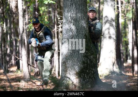 Chris Partridge, un vice di pattuglia dell'ufficio dello sceriffo della contea di Beaufort, si copre dietro un albero mentre persegue un sospetto con Tyler Leduc, un vice di pattuglia dell'ufficio dello sceriffo della contea di Pickens, durante un esercizio di addestramento del 27 settembre 2022 presso la South Carolina Criminal Justice Academy in Columbia. La South Carolina Criminal Justice Academy ha ospitato una settimana Federal Bureaus of Investigation Special Weapons and Tactics Summit per addestrare i funzionari delle forze dell'ordine in armi da fuoco, combattimenti ravvicinati, assistenza medica tattica, tattiche di pattugliamento e familiarizzare gli ufficiali con i dispositivi esplosivi improvvisati. Foto Stock