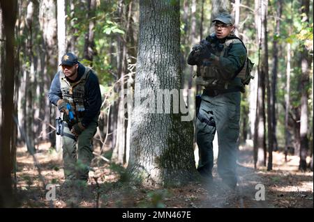 Chris Partridge, un vice di pattuglia dell'ufficio dello sceriffo della contea di Beaufort, si copre dietro un albero mentre persegue un sospetto con Tyler Leduc, un vice di pattuglia dell'ufficio dello sceriffo della contea di Pickens, durante un esercizio di addestramento del 27 settembre 2022 presso la South Carolina Criminal Justice Academy in Columbia. La South Carolina Criminal Justice Academy ha ospitato una settimana Federal Bureaus of Investigation Special Weapons and Tactics Summit per addestrare i funzionari delle forze dell'ordine in armi da fuoco, combattimenti ravvicinati, assistenza medica tattica, tattiche di pattugliamento e familiarizzare gli ufficiali con i dispositivi esplosivi improvvisati. Foto Stock