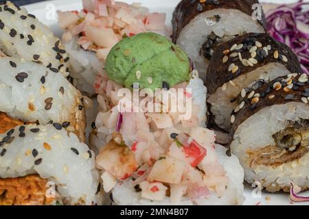 Particolare di pezzi di sushi con bacchette con bacchette e soia. Foto Stock