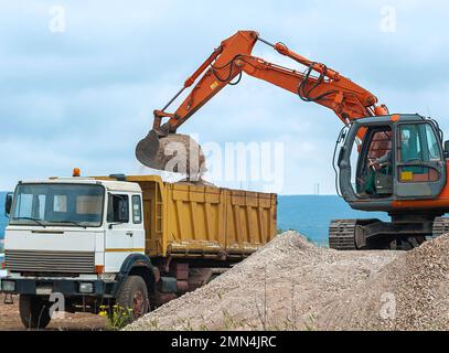 Escavatore e dumper vuoto in cantiere Foto Stock