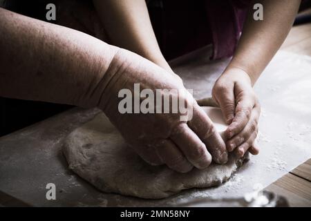 Nonna e nipote che cuocono il pane impastando insieme Foto Stock