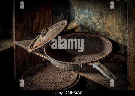 Padella sporca e arrugginita su un ripiano fatiscente in una casa abbandonata, Pennsylvania, USA Foto Stock