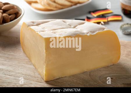 Pezzo di Brugge blomme fresco, formaggio belga, primo piano su un tagliere Foto Stock