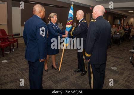 Shanna Woyak, a sinistra, direttore uscente, Small Market and Stand Alone Military Medical Treatment Facility Organization (SSO), E il U.S. Army Lt. Gen. Ronald Place, centro, direttore della Defense Health Agency e il presiedere ufficiale della cerimonia, si scambiano guidon mentre cede il comando della SSO, durante una cerimonia di cambio di direzione, 29 settembre 2022, Port San Antonio, Texas. Foto Stock