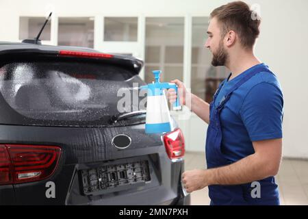 Spruzzare acqua sul finestrino dell'auto prima di colorare Foto Stock