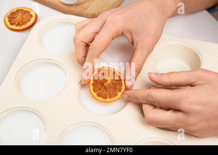 Donna che fa sapone naturale fatto a mano a tavola bianca, primo piano Foto Stock