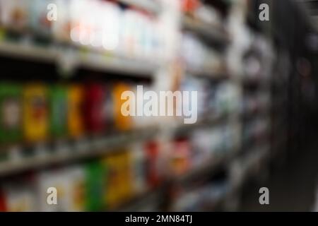 Vista sfocata dei supporti di stoccaggio con materiali da costruzione diversi nel magazzino all'ingrosso Foto Stock