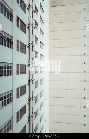 Uno scatto verticale di un'abitazione alta quota con un motivo di piccole finestre e strisce; una vista grandangolare di una facciata di casa residenziale con pl Foto Stock
