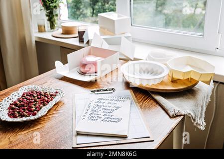 Panetteria piccola impresa locale. Torte speciali per matrimoni, compleanni e anniversari. Il panettiere femminile crea la torta in cucina panetteria. Foto Stock