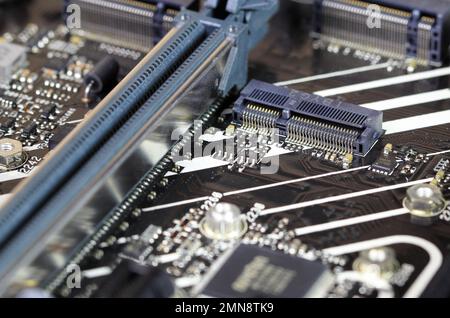 Primo piano dell'interfaccia del connettore maschio a chiave PCIe M.2 e per il modulo WiFi Mini PCIe su un computer moderno ad alte prestazioni. Foto Stock