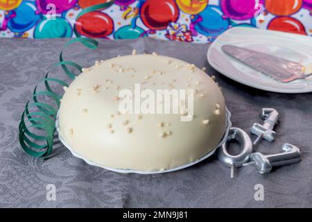 Torta al cioccolato bianco per il compleanno con numero di candele e sfondo con palloncini per la festa Foto Stock