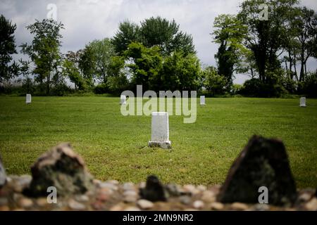 In this Wednesday, May 23, 2018 photo, white markers, each indicating a mass grave of 150 people, are displayed on Hart Island in New York. Officials let reporters get a rare look this week at Hart Island, the place that has served as New York City’s potter’s field for 150 years. (AP Photo/Seth Wenig)