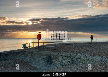 Tramonto sulla spiaggia di Brighton, East Sussex, Inghilterra. West Pier rovine in lontananza. Foto Stock