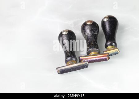 Timbri in gomma di legno usati isolati sulla superficie riflettente. Foto Stock