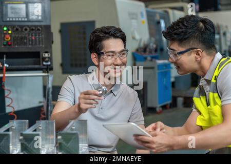 Due tecnici in fabbrica per eseguire la misurazione Foto Stock