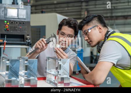 Due tecnici in fabbrica per eseguire la misurazione Foto Stock