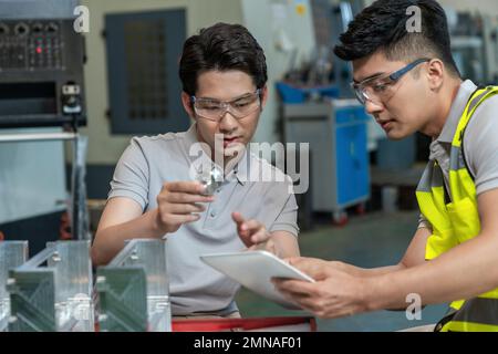 Due tecnici in fabbrica per eseguire la misurazione Foto Stock