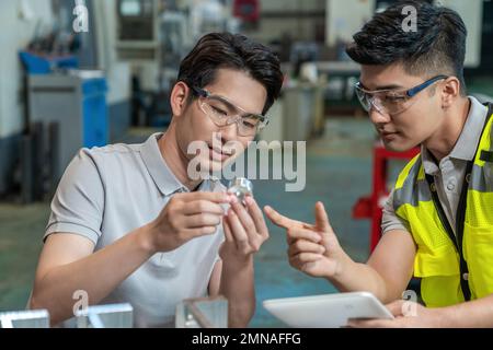 Due tecnici in fabbrica per eseguire la misurazione Foto Stock