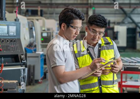 Due tecnici in fabbrica per eseguire la misurazione Foto Stock