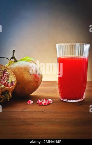 Melograno fresco con succo in bicchiere di vetro Foto Stock