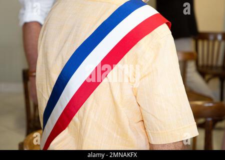 Uomo francese con bandiera ufficiale sciarpa tricolore del sindaco durante la celebrazione in municipio Francia Foto Stock