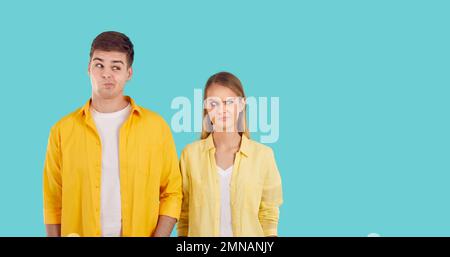 Confuso giovane uomo e donna caucasica che guarda al fianco con il volto divertente insoddisfatto in studio Foto Stock