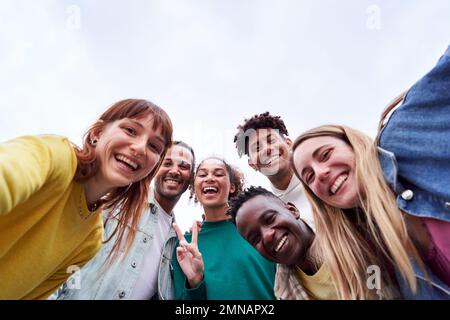 Copia l'immagine spaziale di un gruppo multiculturale di amici che prendono un selfie, guardando la macchina fotografica allegramente. Foto Stock