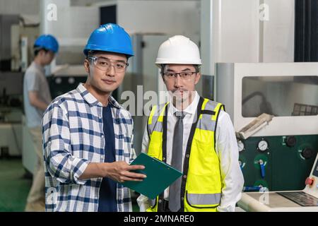 Due ingegneri che lavorano in fabbrica Foto Stock