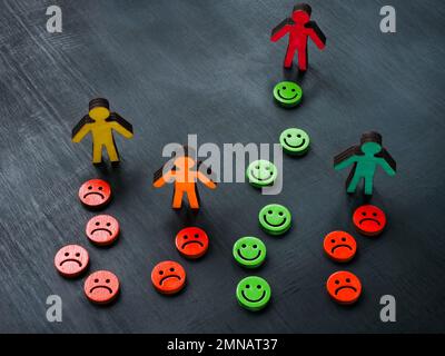 Figure con emoticon felici e infelici. Concetto di benessere e psicologia. Foto Stock