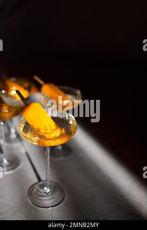Quattro bicchieri di champagne e gelato all'arancia. Elegante cocktail alcolico sul tavolo leggero in morbido sole rayson. Concetto di bevande deliziose. Foto Stock