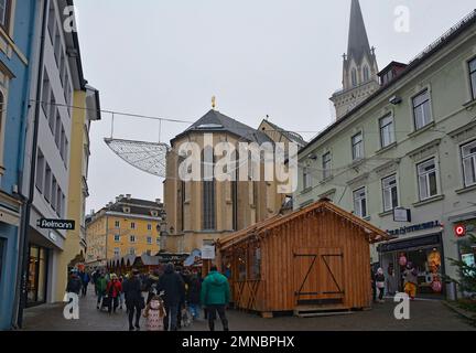 Villach, Austria - Dicembre 24 2022. Bancarelle del mercato di Natale in via Hauptplatz su una lieve nebbia della vigilia di Natale nel centro storico di Villach Foto Stock