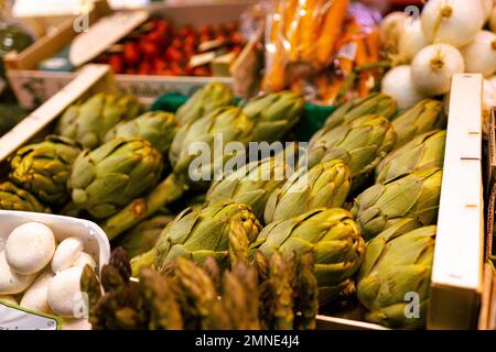 Le verdure belle e sane del carciofo si trovano in scatole di plastica al mercato di strada della Spagna Foto Stock