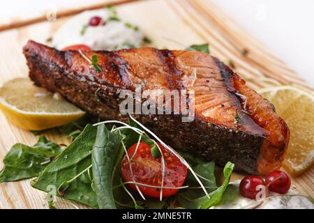 bistecca di salmone alla griglia con limone e pomodori, profondità di campo poco profonda Foto Stock