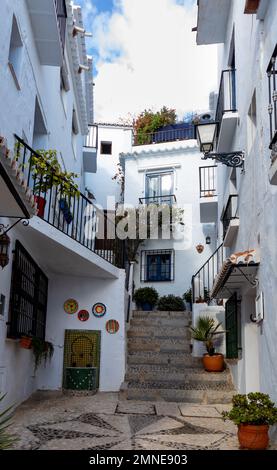 Calle típica de Frigiliana, Málaga, uno de los pueblos más bonitos de España. Con sus paredes blancas, sus calles estrechas y con muchas scaleras Foto Stock