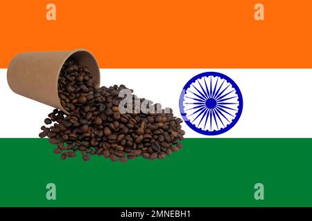 Una tazza di carta monouso capovolta riempita con chicchi di caffè tostati sullo sfondo della bandiera dell'India (primo piano) Foto Stock