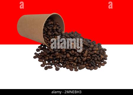 Una tazza di carta monouso capovolta riempita con chicchi di caffè tostati sullo sfondo della bandiera indonesiana (primo piano) Foto Stock