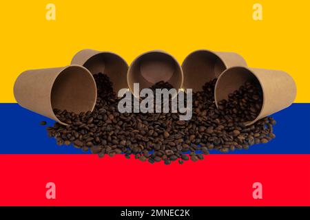 Cinque tazzine di carta usa e getta rovesciate riempite di chicchi di caffè tostati sullo sfondo della bandiera colombiana (primo piano) Foto Stock